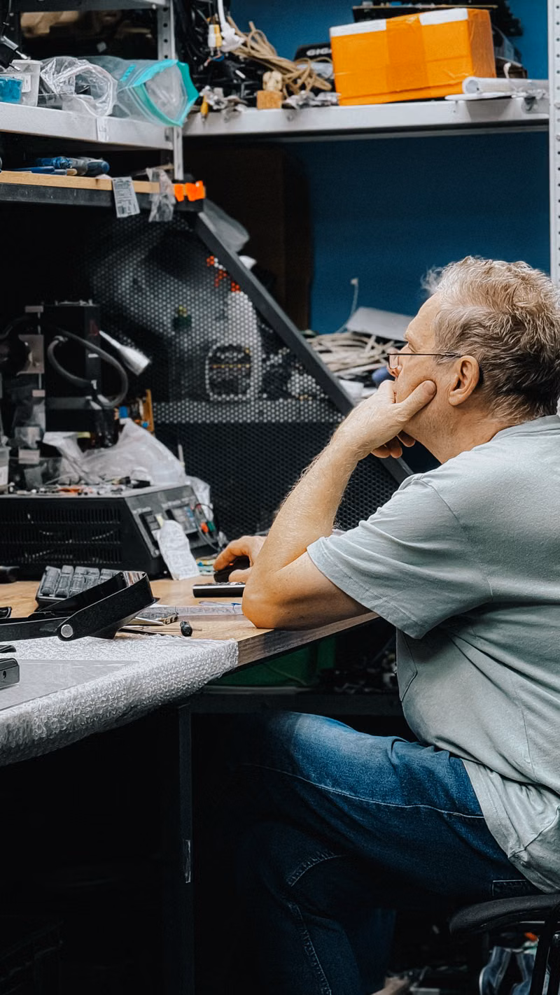 Computer repair technician working vertically at a service bench